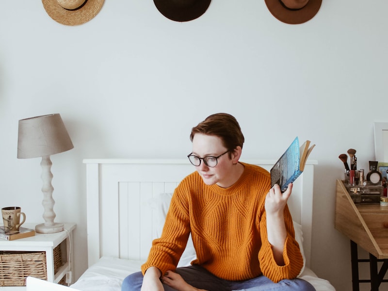 Our location - woman sitting on bed facing laptop
